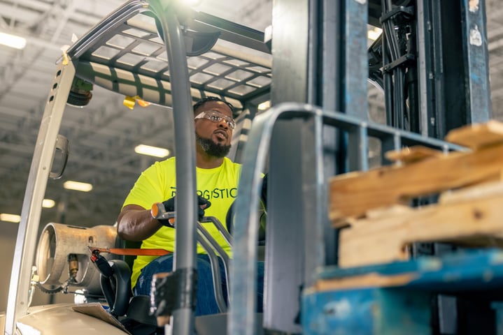 employee driving forklift of pallets